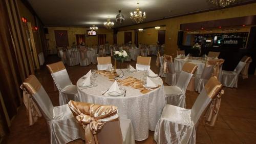 BîrladPensiunea Gallamar的宴会厅配有白色的桌子和白色的椅子