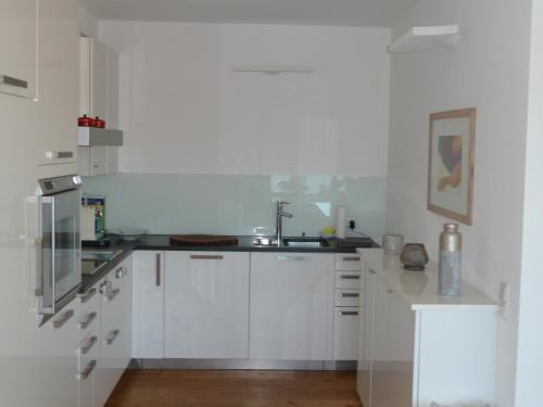 米尔施塔特Weisse Villa的厨房配有白色橱柜和水槽