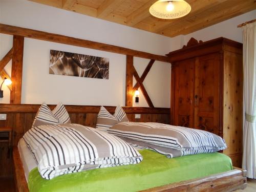 蒙圭尔福Hochwieserhof的一间卧室配有一张带木墙的大床