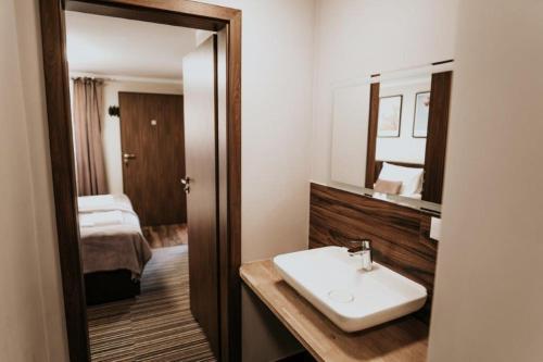 波兰尼卡-兹德鲁伊Villa Paula的一间带水槽和镜子的浴室以及一张床