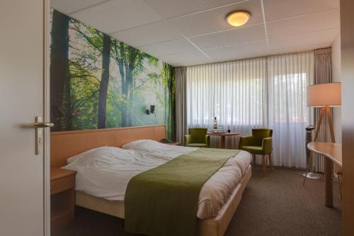 HaarloHCR王子酒店的酒店客房设有一张床,墙上挂有绘画作品