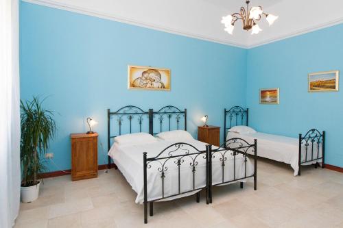 蒂贾诺Li Cuti B&B的一间蓝色卧室,内配两张床