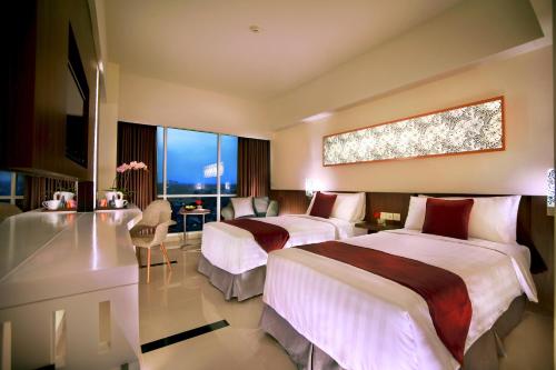 玛琅马朗阿特里亚酒店 的酒店客房配有两张床和一张书桌