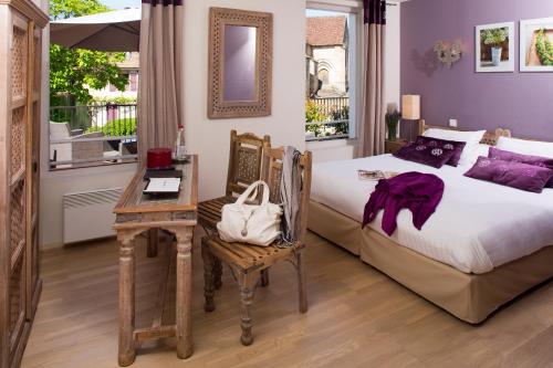 多尔多尼河畔博利厄Logis hotel les flots bleus的一间卧室配有一张床、一张桌子和一张书桌