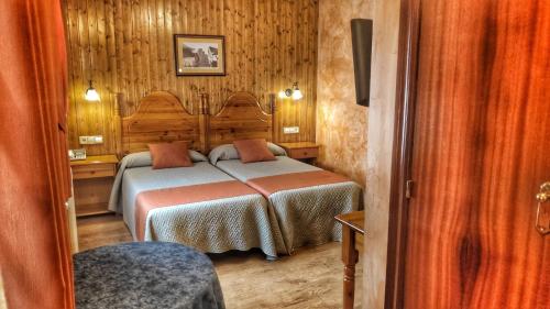 布罗托索落萨尔酒店的卧室配有一张床铺,位于带木墙的房间内