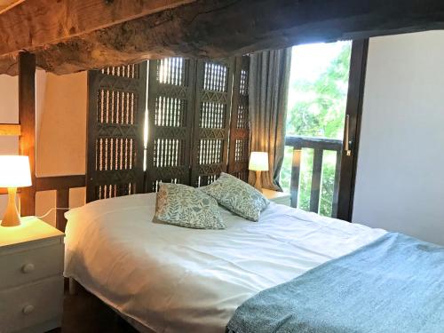 米尔普瓦Hameau de Montcabirol - Pyrénées的一间卧室配有带两个枕头的床和窗户
