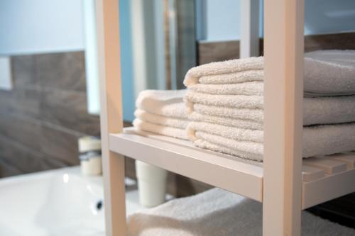 莱维科特尔梅Le quattro stagioni的浴室架子上的一大堆毛巾