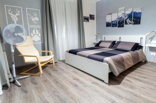莱维科特尔梅Le quattro stagioni的一间卧室配有一张床、一把椅子和风扇