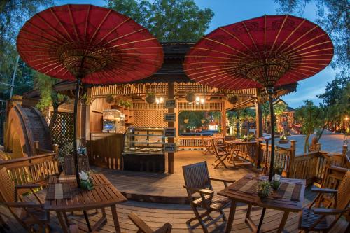 蒲甘蒲甘酒店的一个带桌椅和红色遮阳伞的庭院