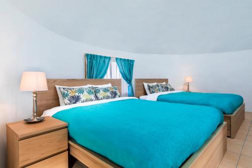 宇流麻Uruma Dome Okinawa的卧室设有两张床铺,配有蓝色床单