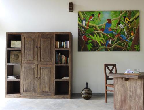 HunumullaAmbarella Lodge - Katunayake的书架和墙上绘画的房间