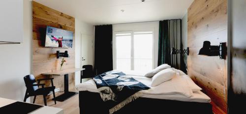 索特KIDE hotel by Iso-Syöte的一间卧室配有一张床、一张书桌和一个窗户。