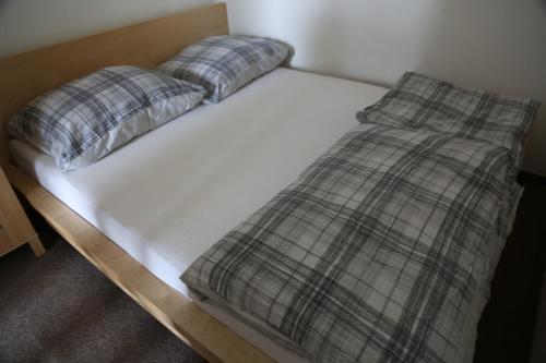 布拉格Praha 2的一张带两个枕头的白色床