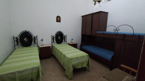 拉卡莱Casa Della Nonna的配有绿床单的客房内的两张床