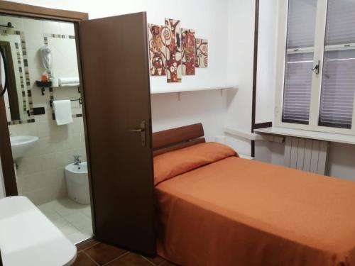 奇维塔韦基亚阿尔博奥洛拉伊酒店的一间带床的小卧室和一间浴室