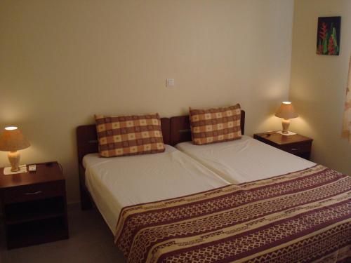 DomburgSurinat Luxury Resort的一间卧室配有一张带两张台灯的床铺。