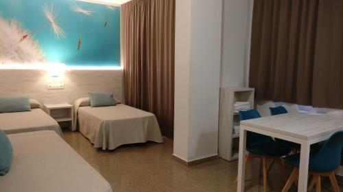 罗列特海岸马利波萨公寓式酒店的酒店客房带一张床、一张桌子和椅子