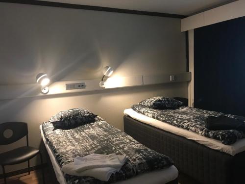 科拉里Hotelli Kolari的墙上灯的房间里设有两张床