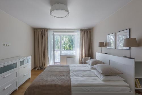 希奥利艾Sun City Apartment的白色的卧室设有一张大床和一个窗户