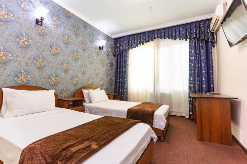 泰尔梅兹Asson Hotel Termez的酒店客房设有两张床和窗户。