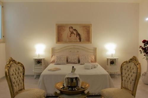 佩兹迪格雷科De Mola Holiday House的一间卧室配有一张带两把椅子和一张桌子的床。