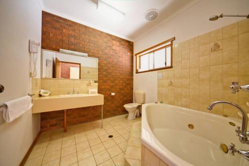 谢珀顿谢珀顿天堂湖汽车旅馆的带浴缸、盥洗盆和卫生间的浴室