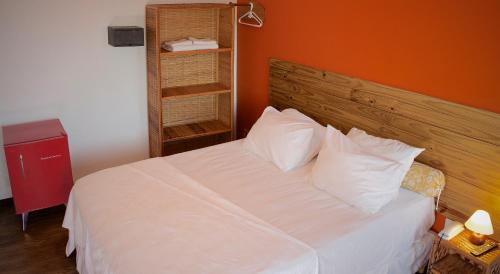 萨尔瓦多斯特拉热带酒店的一间卧室配有一张白色的床和橙色的墙壁