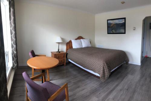 康沃尔世纪汽车旅馆 的酒店客房带一张床、一张桌子和椅子