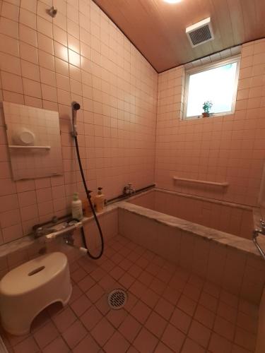 白马村林住宿加早餐旅馆的一间带卫生间和浴缸的浴室