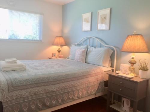 温哥华Sun House的一间卧室配有一张蓝色墙壁的床和两盏灯。