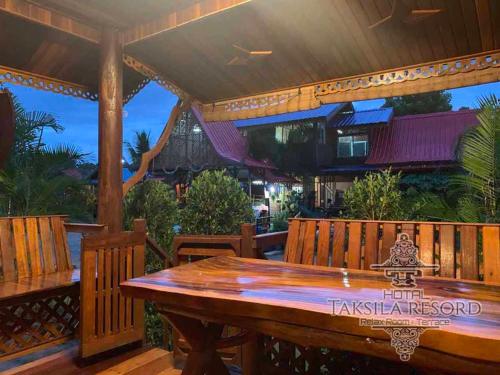 Ban Nong LupTaksila Resort ฏักร์ศิลารีสอร์ท的用餐区设有木桌和长凳
