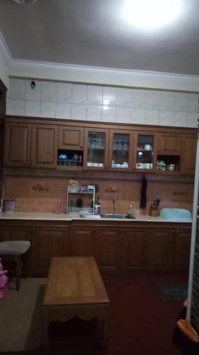 玛琅Nusin 54 Homestay的厨房配有木制橱柜、水槽和桌子