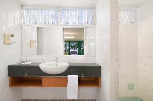 格拉德斯通South Gladstone Motel的一间带水槽和镜子的浴室