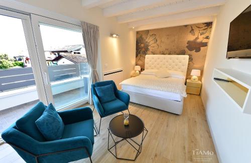 龙基德伊莱焦纳里TiAMo Modern Design Guest House的一间卧室配有一张床和两张蓝色椅子