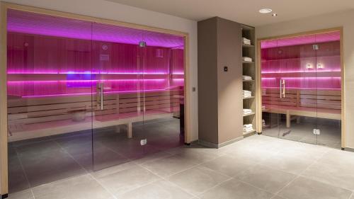 蒂门多弗施特兰德蒂门多弗施特兰德乡村酒店的墙壁上设有紫色灯的浴室