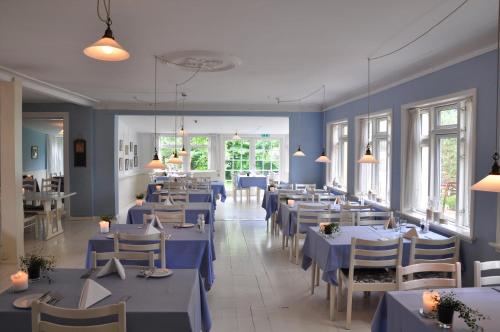 坎迪斯蒂德尼霍约斯巴德酒店的餐厅设有蓝色的桌椅和窗户。