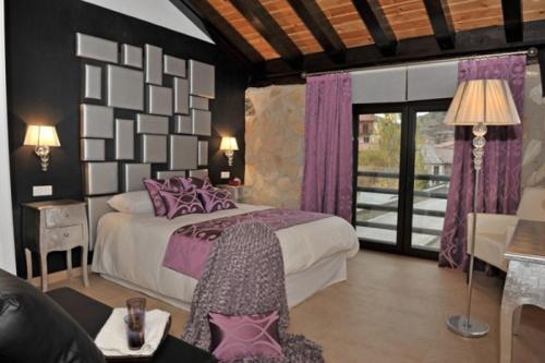 乌塞罗El Balcon Del Cañon的一间卧室配有一张带紫色枕头的大床