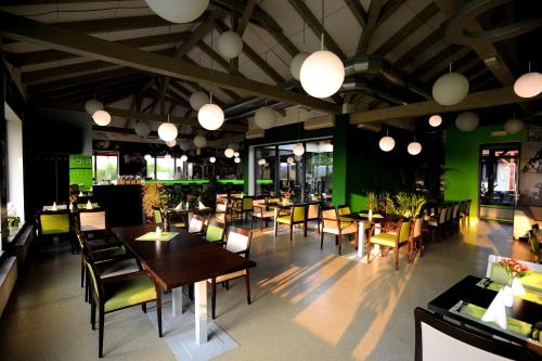 布拉格黑桥酒店公寓的餐厅设有木桌和椅子,拥有绿色的墙壁