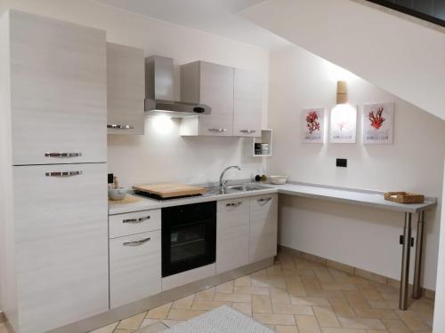 SquinzanoDimora Tra I Due Mari的白色的厨房配有白色橱柜和水槽