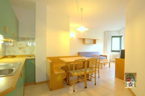 科马诺泰梅Residenza Artini的厨房以及带桌椅的用餐室。