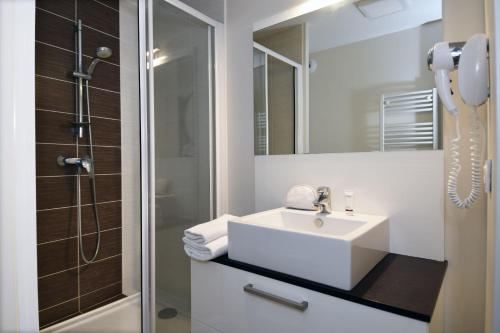 拉格朗德默特Résidence Odalys Les Dunes du Soleil的白色的浴室设有水槽和淋浴。