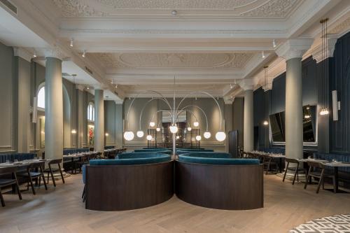 伦敦The Clermont London, Victoria的一间配备有蓝色椅子和桌子的用餐室