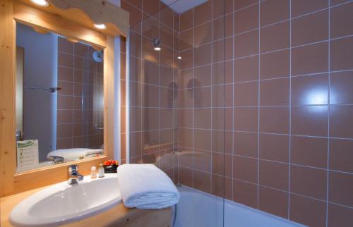 德沃吕伊Résidence Odalys L'Orée des Pistes的浴室配有盥洗盆、镜子和浴缸