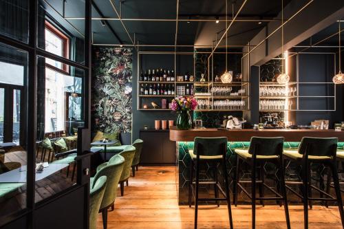 根特Maison Margo的一间设有绿色椅子的餐厅和一间酒吧