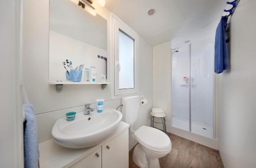 巴多利诺Albatross Mobile Homes on Camping Cisano & San Vito S. p. A.的白色的浴室设有卫生间和水槽。