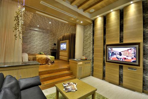 台中市海顿汽车旅馆的带电视的客厅和卧室。