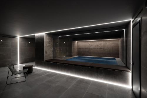 马泰拉La Suite Matera Hotel & Spa的客房设有带椅子的游泳池和浴缸