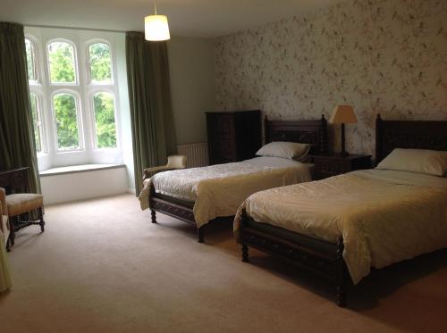 惠灵顿格林汉姆霍尔住宿加早餐旅馆的一间卧室设有两张床和窗户。