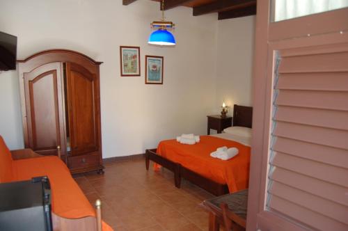弗卡诺Hotel Al Togo Fitness & Relax的一间卧室配有带橙色床单和蓝色灯光的床。