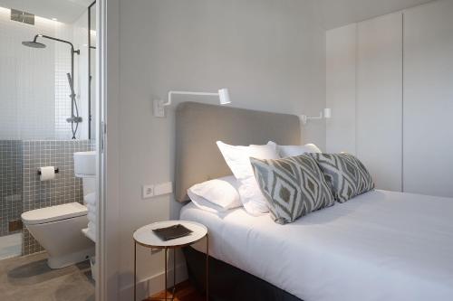 扎鲁亚斯ATeRIAN MUSKARIA的一间卧室配有一张带桌子和淋浴的床